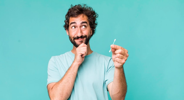 Young adult hispanic crazy man using an ear swab