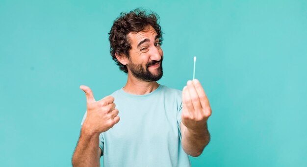 Young adult hispanic crazy man using an ear swab