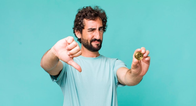 Young adult hispanic crazy man with a bitcoin coin