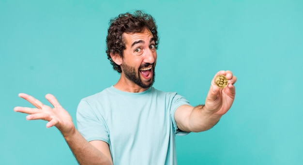 Young adult hispanic crazy man with a bitcoin coin