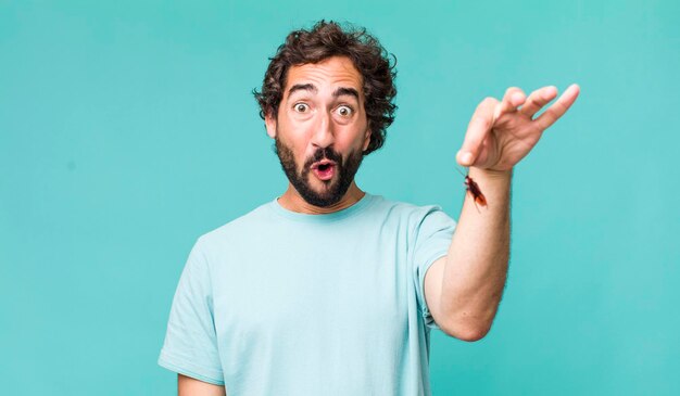 Young adult hispanic crazy man with a cockroach insect