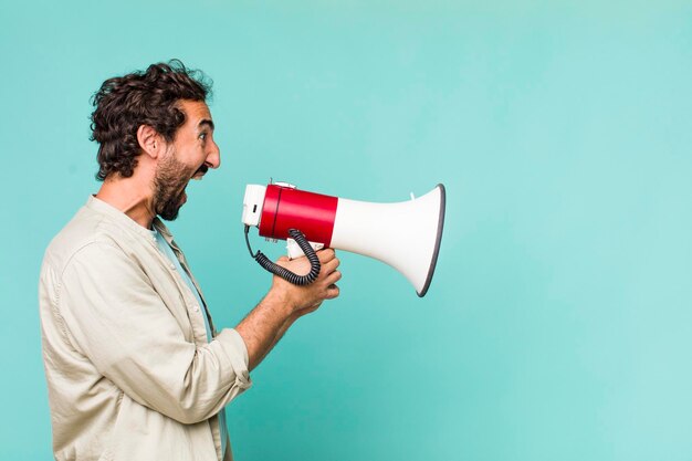 Young adult hispanic crazy man with a megaphone