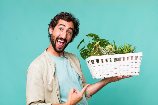 Young adult hispanic crazy man with plants gardering concept