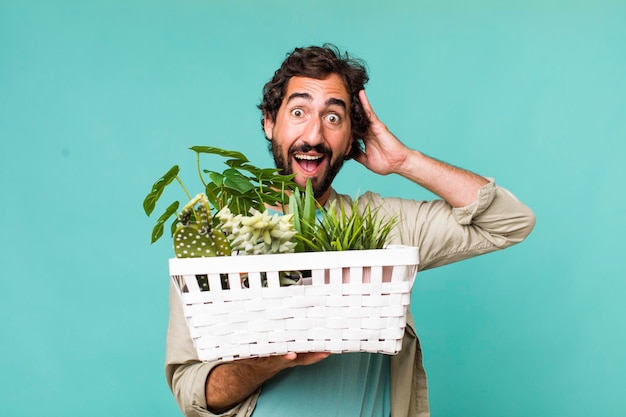 Young adult hispanic crazy man with plants gardering concept