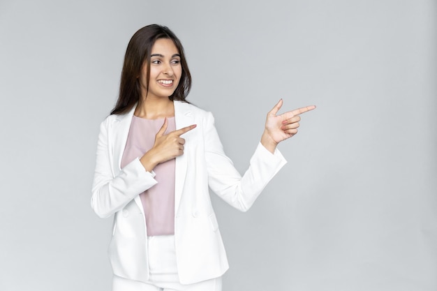 Young adult indian woman smiling and pointing away