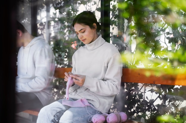 Young adult knitting outside