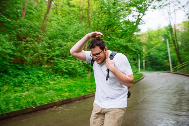 Photo young adult main running under the rain rainy weather