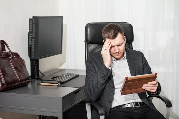 Young adult male businessman at his Desk with a computer in the office during working hours