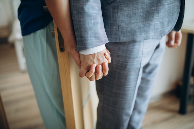 Young adult male groom and female bride holding hands