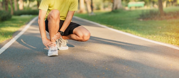 Giovane maschio adulto con il suo dolore muscolare durante la corsa corridore uomo che ha dolore alle gambe a causa di distorsioni della caviglia o tendinite di achille lesioni sportive e concetto medico