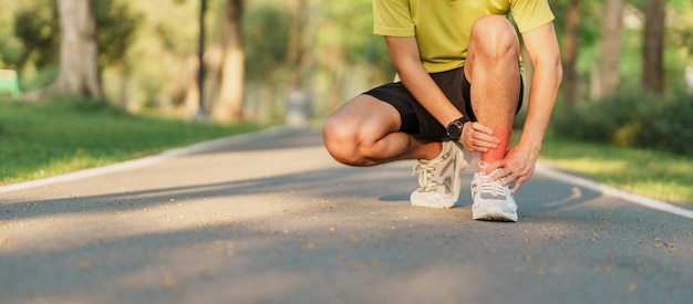 Young adult male with his muscle pain during running runner man having leg ache due to Ankle Sprains or Achilles Tendonitis Sports injuries and medical concept