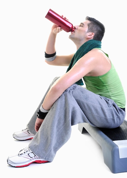 Молодой взрослый мужчина расслабляется и пьет воду с потом на теле