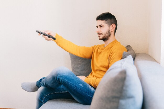 Young adult man watching a movie on television at home.concept\
of relaxation, entertainment, video and technology indoors.