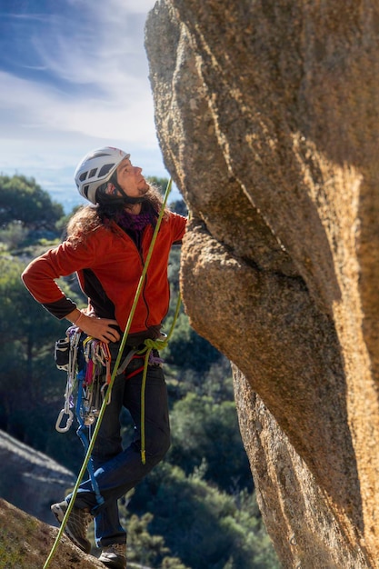 Foto giovane adulto che prepara la sua prossima mossa mentre si arrampica su una parete di granito a torrelodones madrid concetto di sport estremi