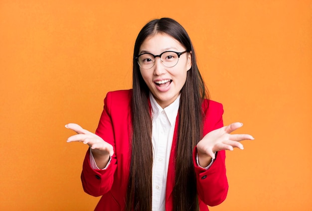 Young adult pretty asian businesswoman wearing red blazer and glasses