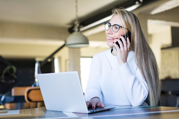 自宅でラップトップを使用する若い大人のかなり金髪の女性