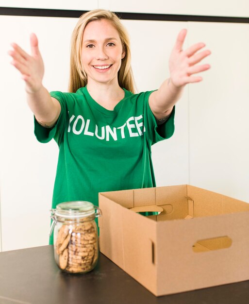 Photo young adult pretty blonde woman volunteer and donation concept