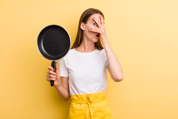 Young adult pretty chef woman with a pan