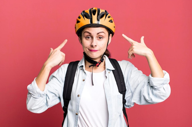 自転車のヘルメットとバッグを持つ若い大人のきれいな配達女性