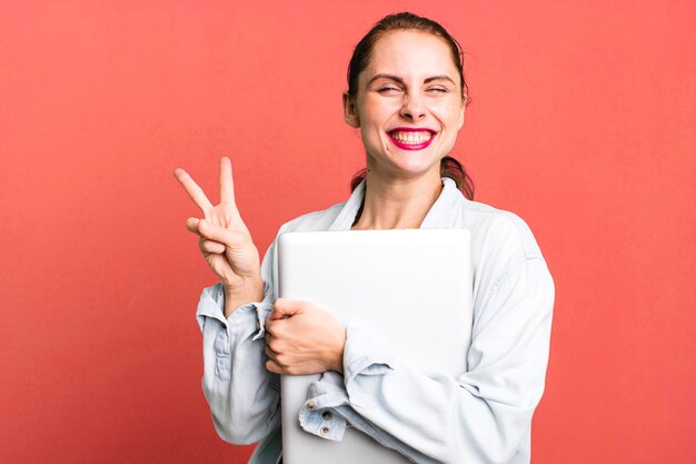 Young adult pretty university student woman with a laptop