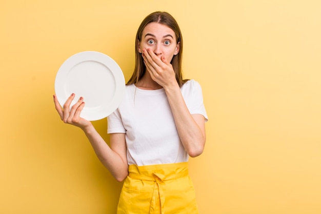 Young adult pretty woman chef with an empty dish