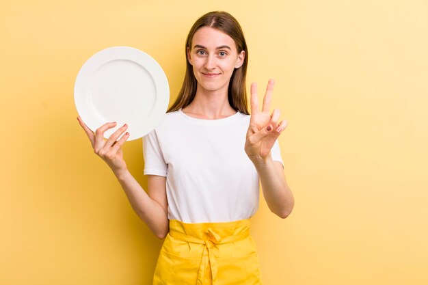 Young adult pretty woman chef with an empty dish