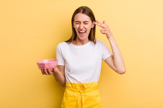 Young adult pretty woman empty cooking bowl concept