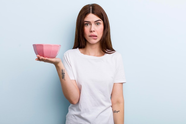 Young adult pretty woman holding an empty bowl