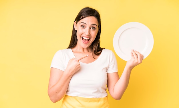 Young adult pretty woman home chef with empty plate