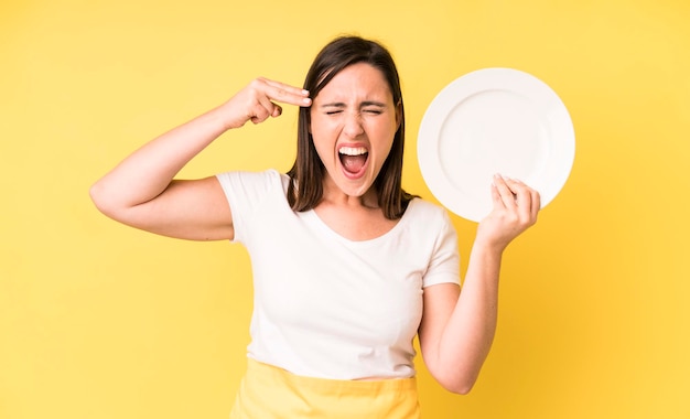 Young adult pretty woman home chef with empty plate