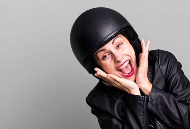 Young adult pretty woman motorbike rider with leather jacket and helmet