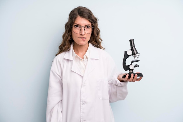 Young adult pretty woman scientist student with a microscope