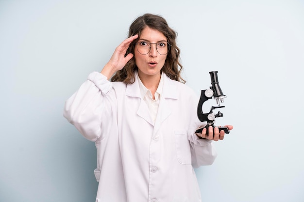 Young adult pretty woman scientist student with a microscope
