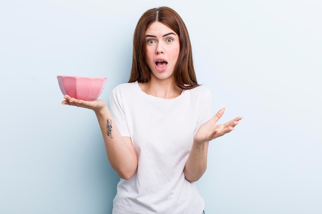 Young adult pretty woman with an empty bowl copy space