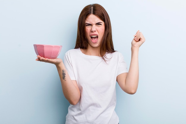 Young adult pretty woman with an empty bowl copy space