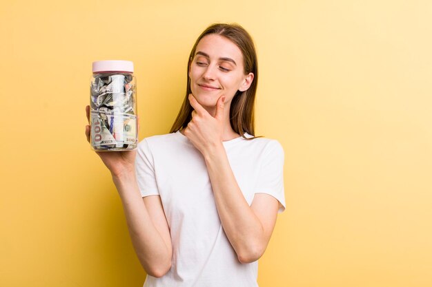 Young adult pretty woman with her savings bottle