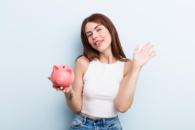 Young adult pretty woman with a piggy bank savings concept