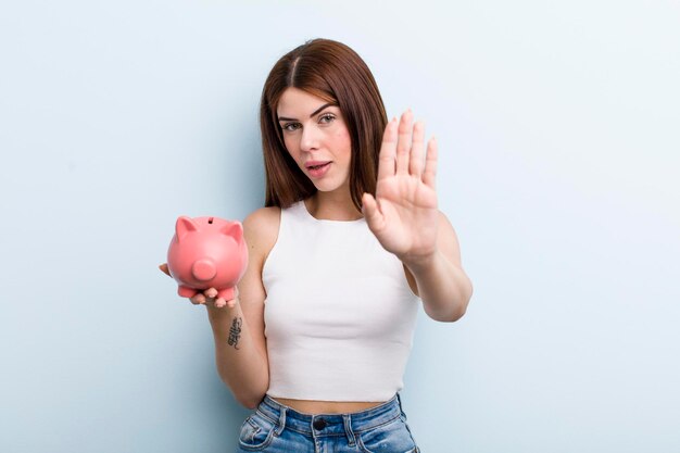 Young adult pretty woman with a piggy bank savings concept