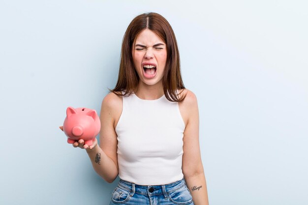 Young adult pretty woman with a piggy bank