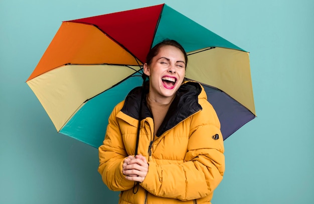 Young adult pretty woman with an umbrella rain winter and cold concept