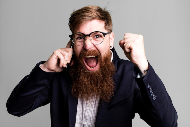 Young adult red hair bearded cool businessman using his smartphone