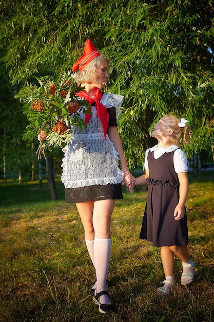 Young and adult schoolgirl on september with flowers generations of schoolchildren of ussr and