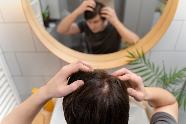 Photo young adult searching their hair for dandruff