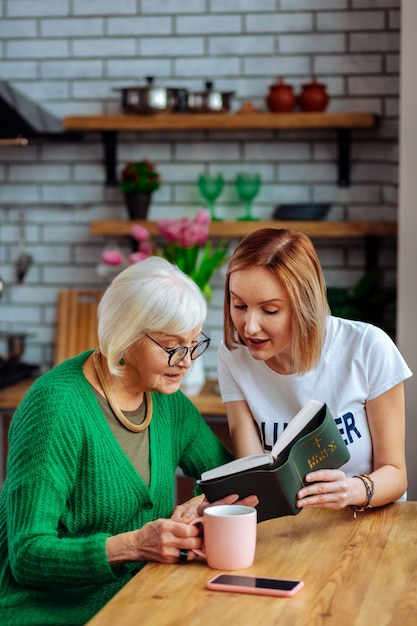 young adult volunteer discussing with an aging woman in the kitchen