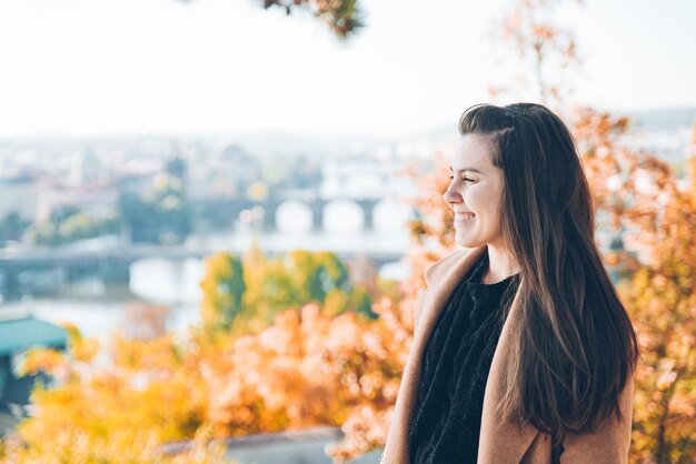 Young adult woman in coat beautiful prague on background