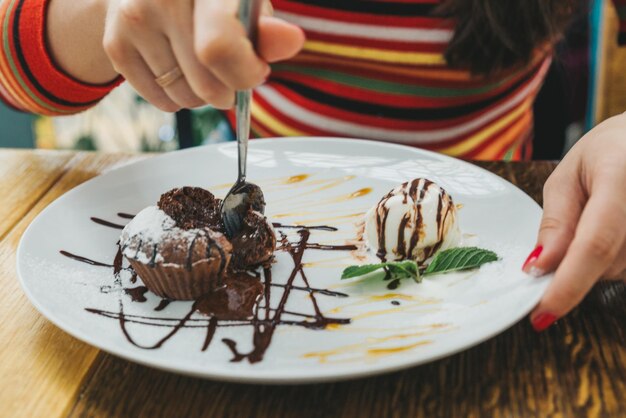 写真 カフェでチョコレートフォンダンを食べている若い成人女性