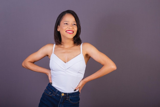 Young adult woman from northeastern brazil hands on hips smiling and confident