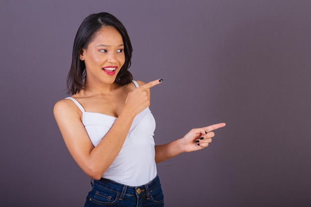 右の宣伝写真を指しているブラジル北東部の若い成人女性