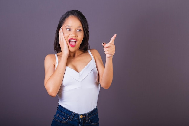 Young adult woman from northeastern brazil Pointing to something far away indicating choosing