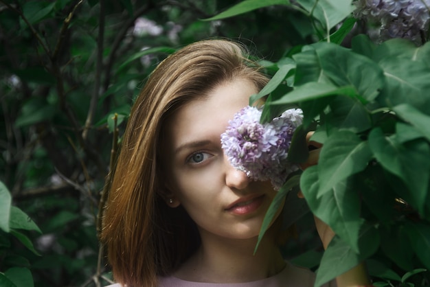 Young adult woman in lilac bush